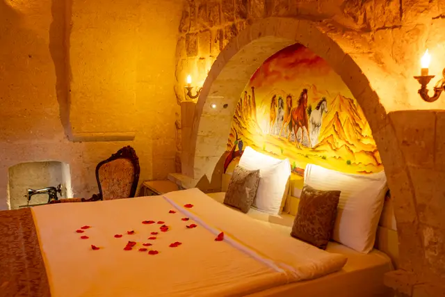 A decorated bedroom set within carved stone walls.