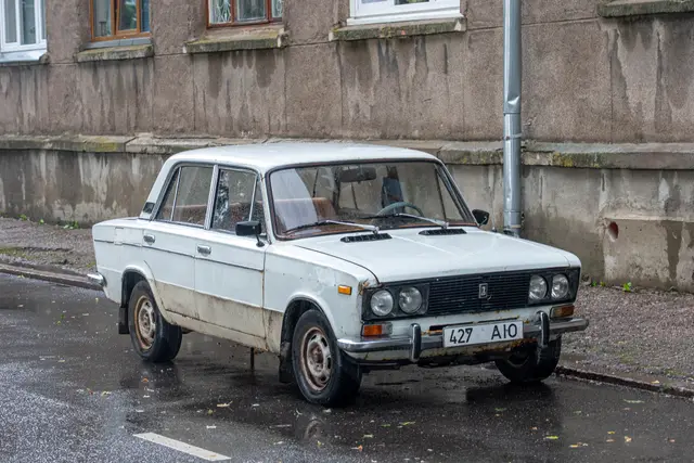 An old Soviet-era Lada parked on a quiet street.